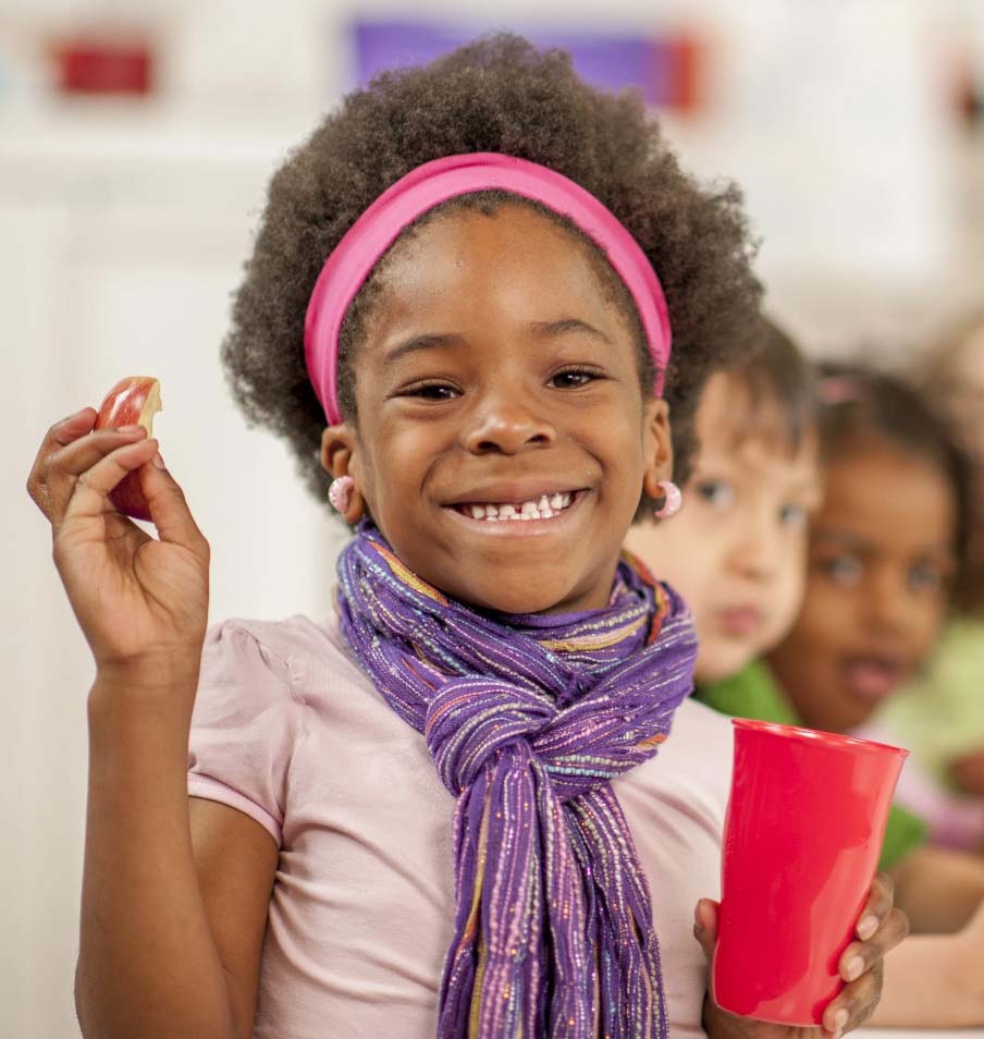 Smiling girl eating an apple