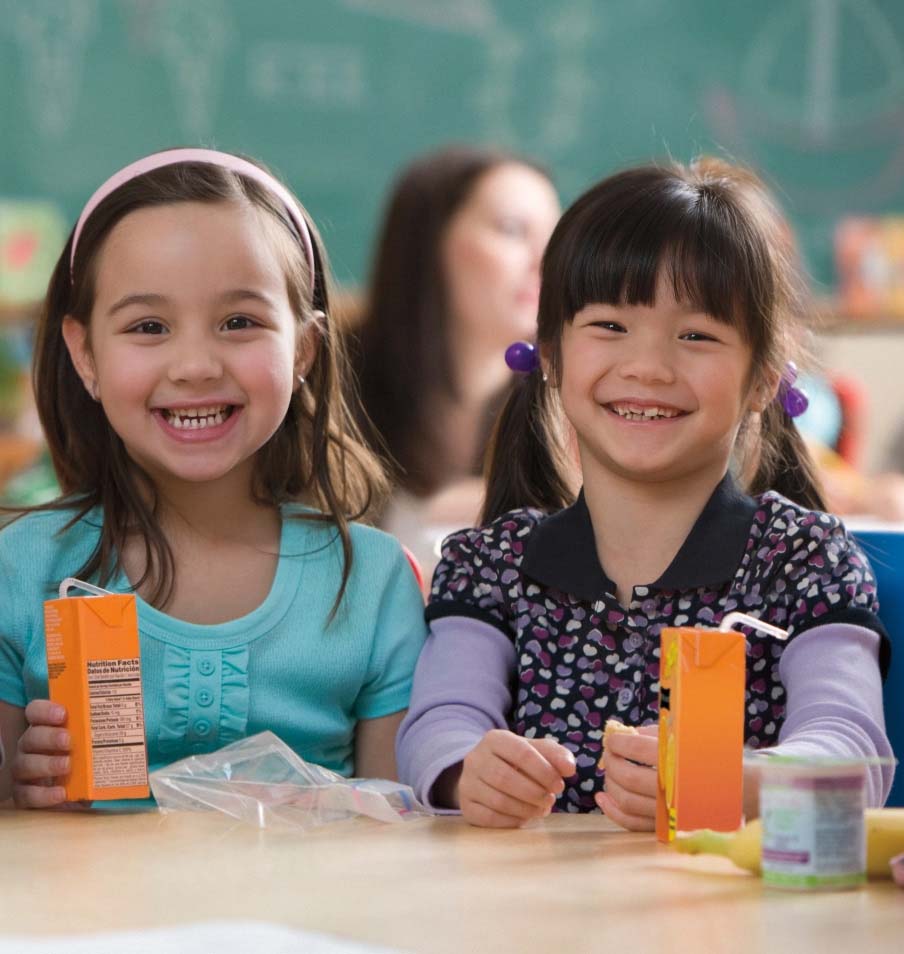 Two smiling girls eating lunch